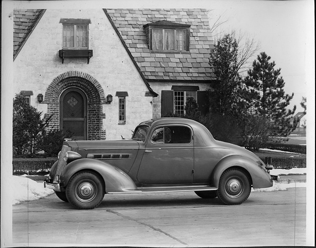 1935 Packard sport coup, left side view, parked in front of the Lodge