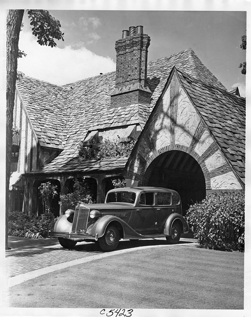 1936 Packard sedan, three-quarter left front view, parked in driveway of home