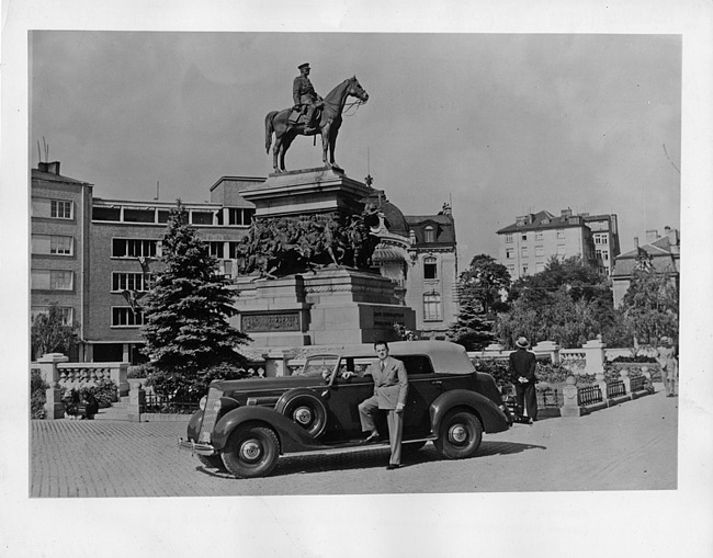 1936 Packard convertible sedan, parked on street in front of 'King Liberator's' monument