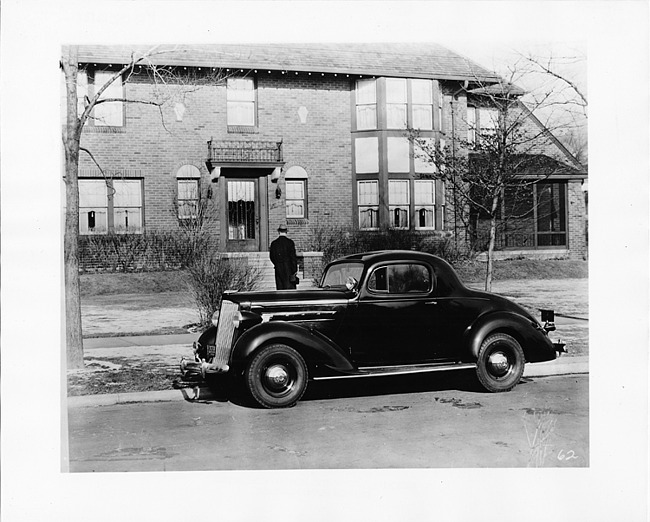 1937 Packard business coupe, parked on street in front of brick house