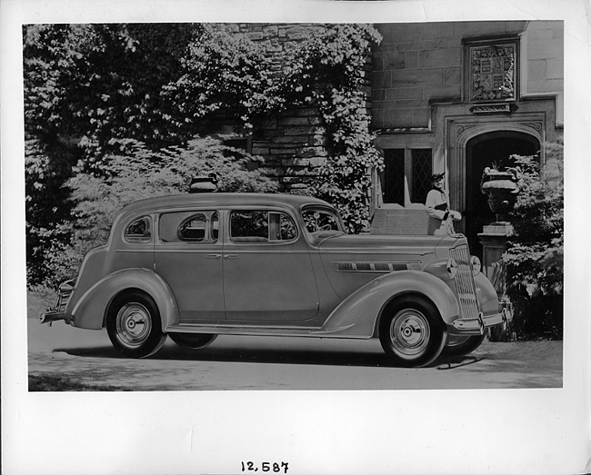 1937 Packard touring sedan, parked on drive in front of house