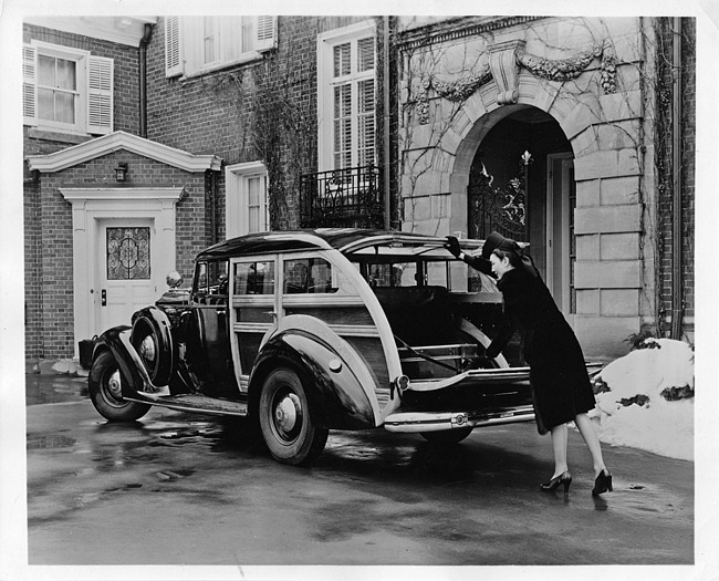 1937 Packard special station wagon, female reaching to get suitcase out of back