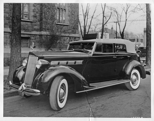 1937 Packard convertible sedan, three-quarter left front view, top raised, parked by church