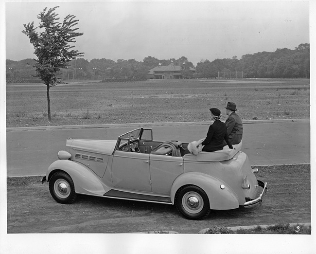 1937 Packard convertible sedan, couple sitting on folded top at Belle Isle