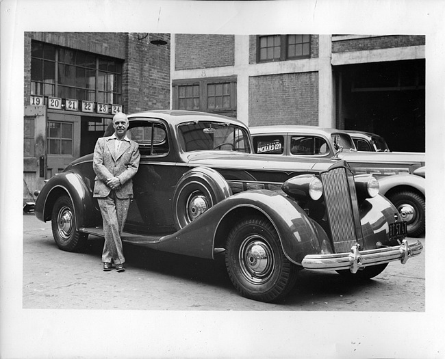 1937 Packard coupe, three-quarter right side view, owner standing at passenger side door