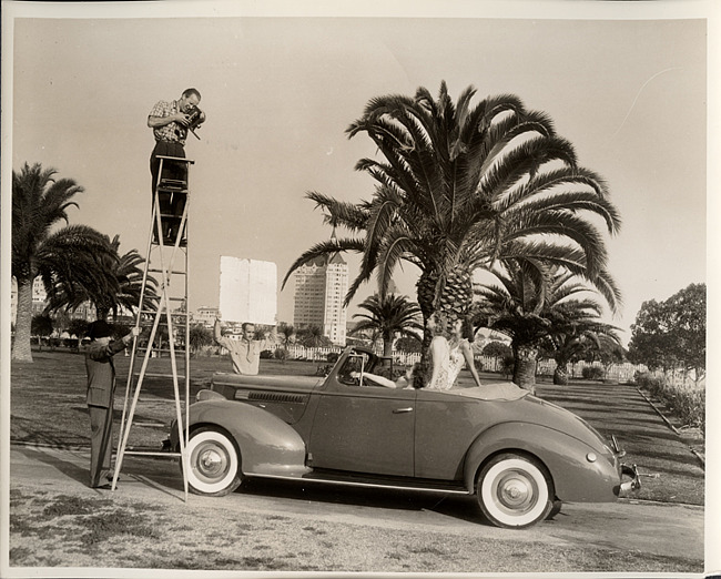 1939 Packard convertible coupe in California with bathing beauties posing for photographer