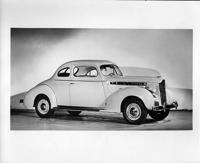 1940 Packard club coupe, nine-tenths right side view, male behind wheel