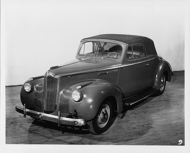 1941 Packard convertible coupe, three-quarter front left view, top raised