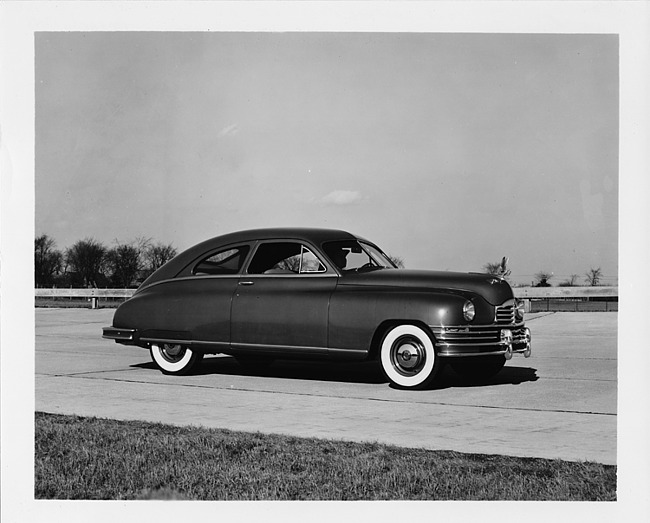 1948 Packard sedan, male behind wheel, on track at Packard Proving Grounds