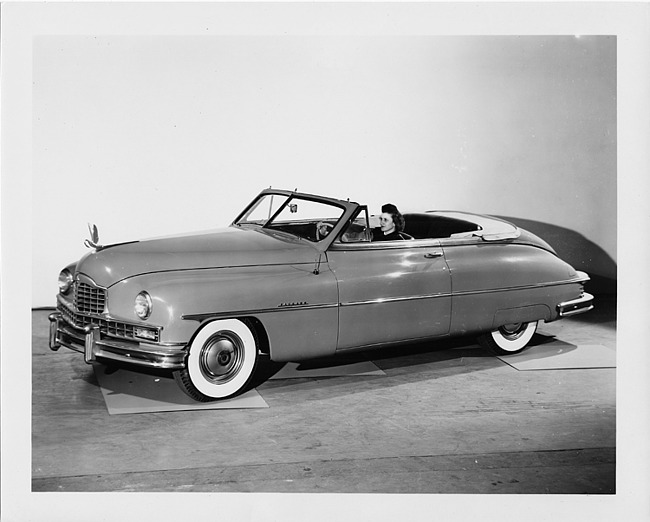 1950 Packard custom convertible, top folded, female behind wheel