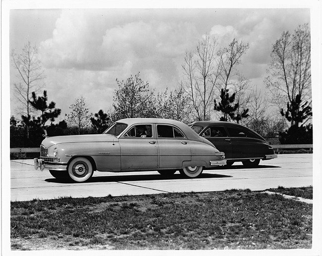 1950 Packard sedans, male drivers, parked on drive