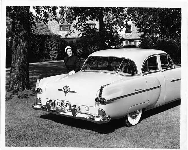 1951 Packard 300, parked on grass, female standing at left side of trunk