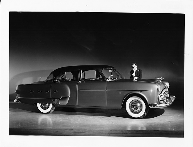 1952 Packard 400 Patrician, nine-tenths right side view, female leaning on driver side of hood