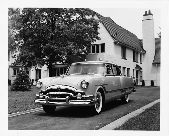 1953 Packard touring sedan, parked in driveway in front of house