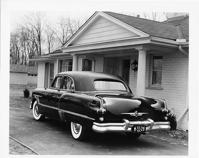1953 Packard formal sedan, parked in driveway in front of house