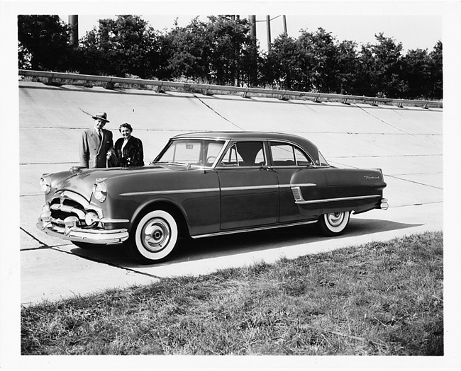 1954 Packard sedan at Packard Proving Grounds, on track next to couple