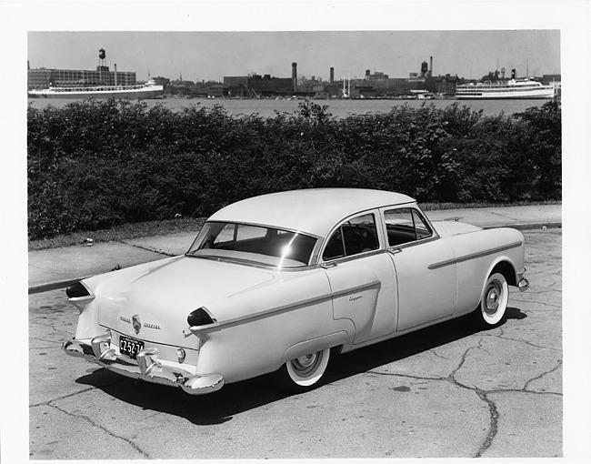 1954 Packard Clipper, parked on street, river and boats in background