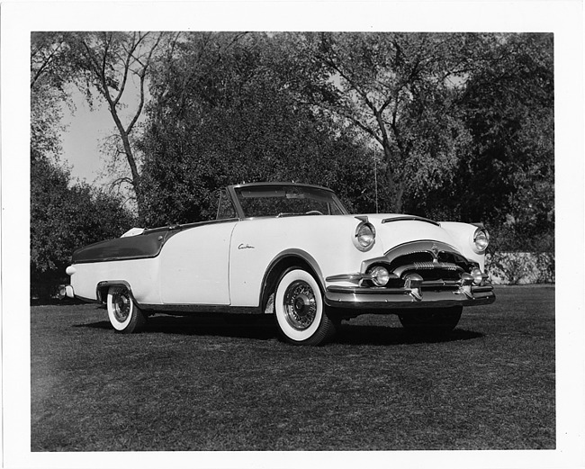 1954 Packard Caribbean, three-quarter front left view, top folded, parked on grass