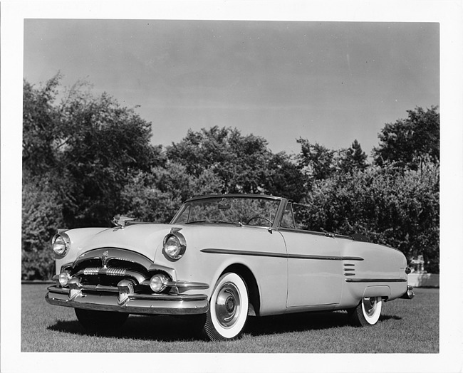 1954 Packard convertible coupe, three-quarter front left view, top folded, parked on grass