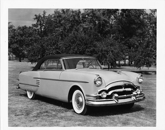 1954 Packard convertible, three-quarter right side view, top raised, parked on grass