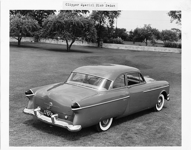 1954 Packard 2-door sedan, three-quarter right rear view, parked on grass