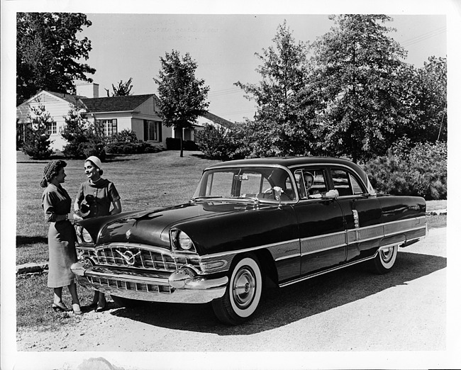1956 Packard 2-door sedan, female behind wheel, two females standing at front passenger side