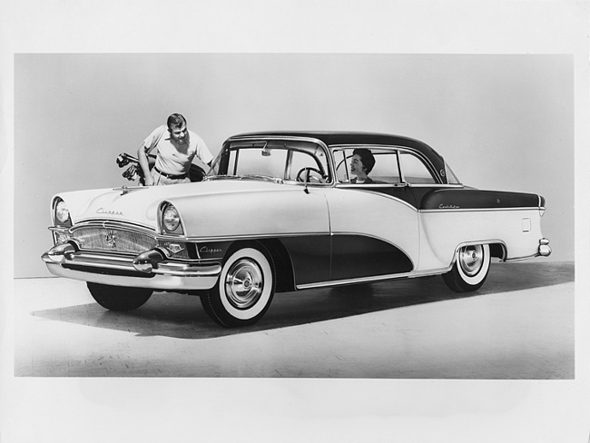 1955 Packard Clipper Constellation on display with man holding golf clubs