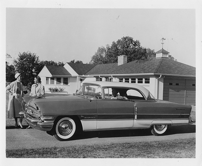 1956 Packard sedan, woman behind wheel, two women standing at front of car