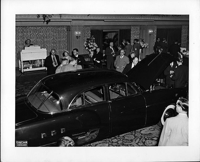 1951 salon showing a 1951 Packard 4-door sedan, crowd surrounding car