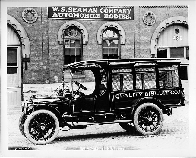 1914 Packard truck, left side view, parked on street in front of W.S. Seaman Company building