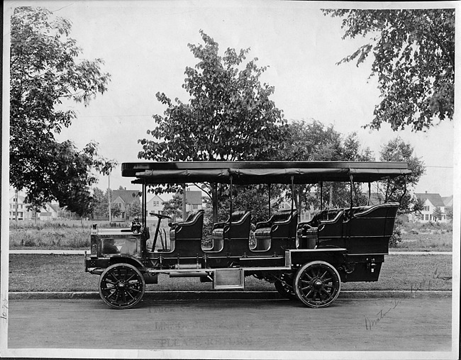 1910 Packard jitney bus, left side view, parked on street
