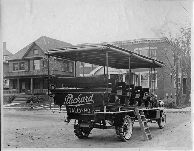 1910 Packard jitney bus, three-quarter rear view, parked on street