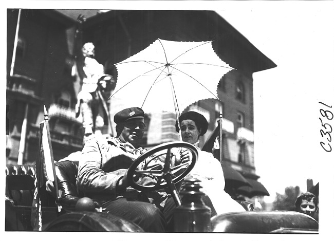 Man and woman sitting in car with umbrella at the 1909 Glidden Tour, Detroit, Mich.