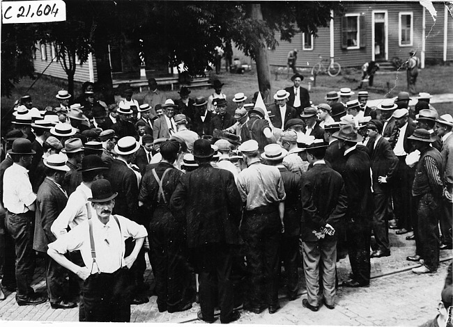 Hupmobile and Brush runabout cars surrounded by crowd of men in South Bend, Ind. at 1909 Glidden Tour