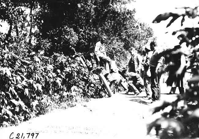 Front of car sticking out of bushes along the side of a rural road, at 1909 Glidden Tour