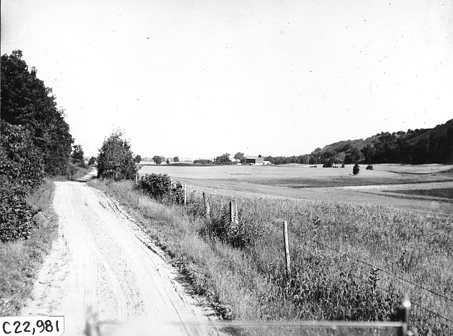 View of rural road and countryside from the back of car at 1909 Glidden Tour