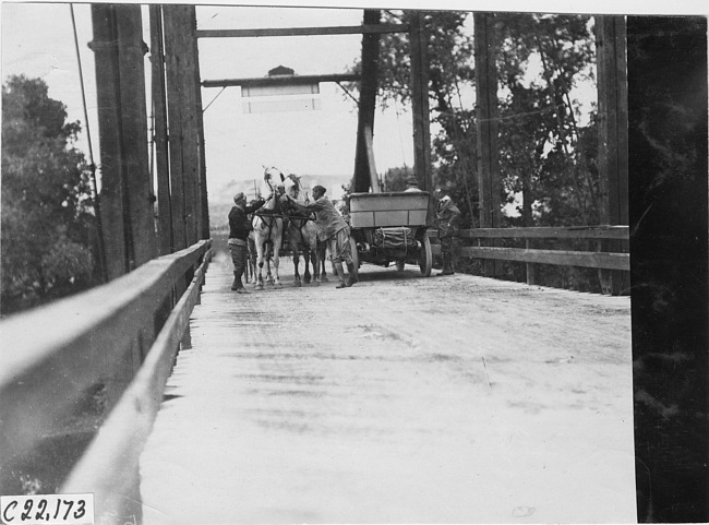 Chalmers car next to horse drawn vehicle on bridge in Winona, Wis., 1909 Glidden Tour