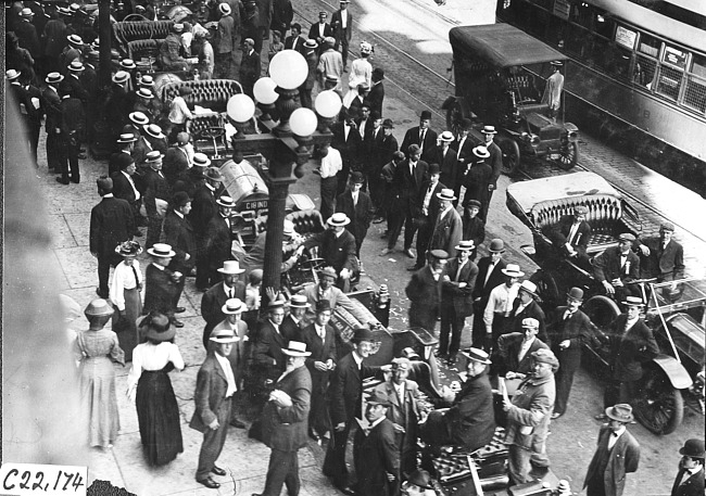 Bird's eye view of crowd surrounding Glidden tourists as they arrive at the West Hotel in Rochester, Minn., at the 1909 Glidden Tour