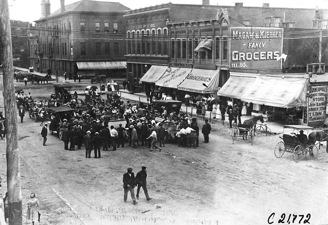 Bird's eye view of crowd greeting Glidden tourists in Rochester, Minn., at the 1909 Glidden Tour