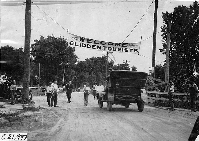 Glidden tourist car passes under welcome banner at Council Bluffs, Iowa at 1909 Glidden Tour