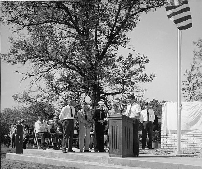 Memorial Dedication Bob Sutton speaks at lecturn, Bill Jens stands second from l
