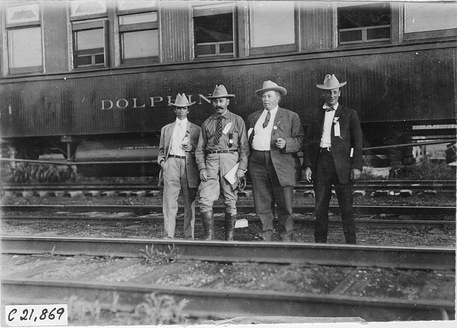 George Smithson and three newspaper men posed in front of Pullman car in Kearney, Neb., at 1909 Glidden Tour