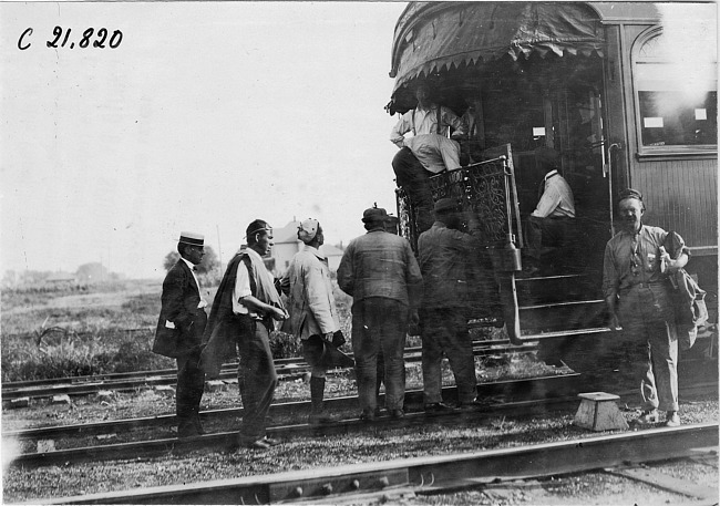 Glidden tourists standing in line at back of Pullman car to receive letters from home in Kearney, Neb., at 1909 Glidden Tour