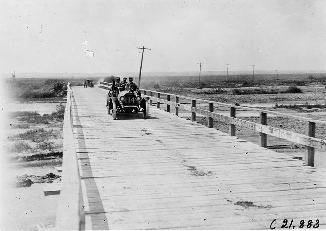 John C. Moore driving the Lexington car #114 over bridge, at the 1909 Glidden Tour