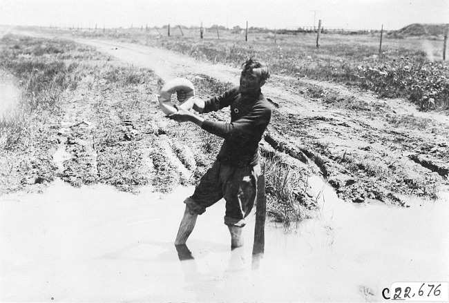 Don McIntosh standing in muddy water on the Colorado prairie, at 1909 Glidden Tour