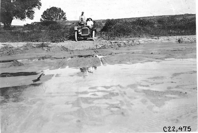 Glidden tourist vehicle stopped before a large muddy hole, at 1909 Glidden Tour