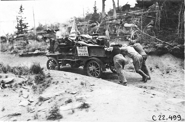 Glidden tourists pushing Rapid motor truck on sandy mountain road in Colo., at 1909 Glidden Tour