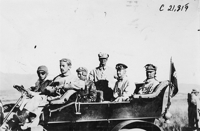 Glidden tourists pose in vehicle on rural road in Colo., at 1909 Glidden Tour