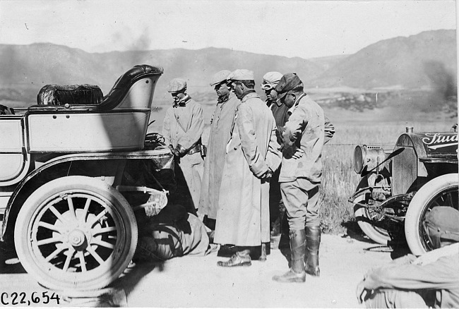 Glidden tourists watch man work on car near Colorado Springs, Colo., at 1909 Glidden Tour