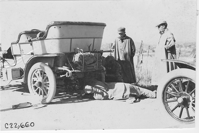 Man works under car while others watch near Colorado Springs, Colo., at 1909 Glidden Tour